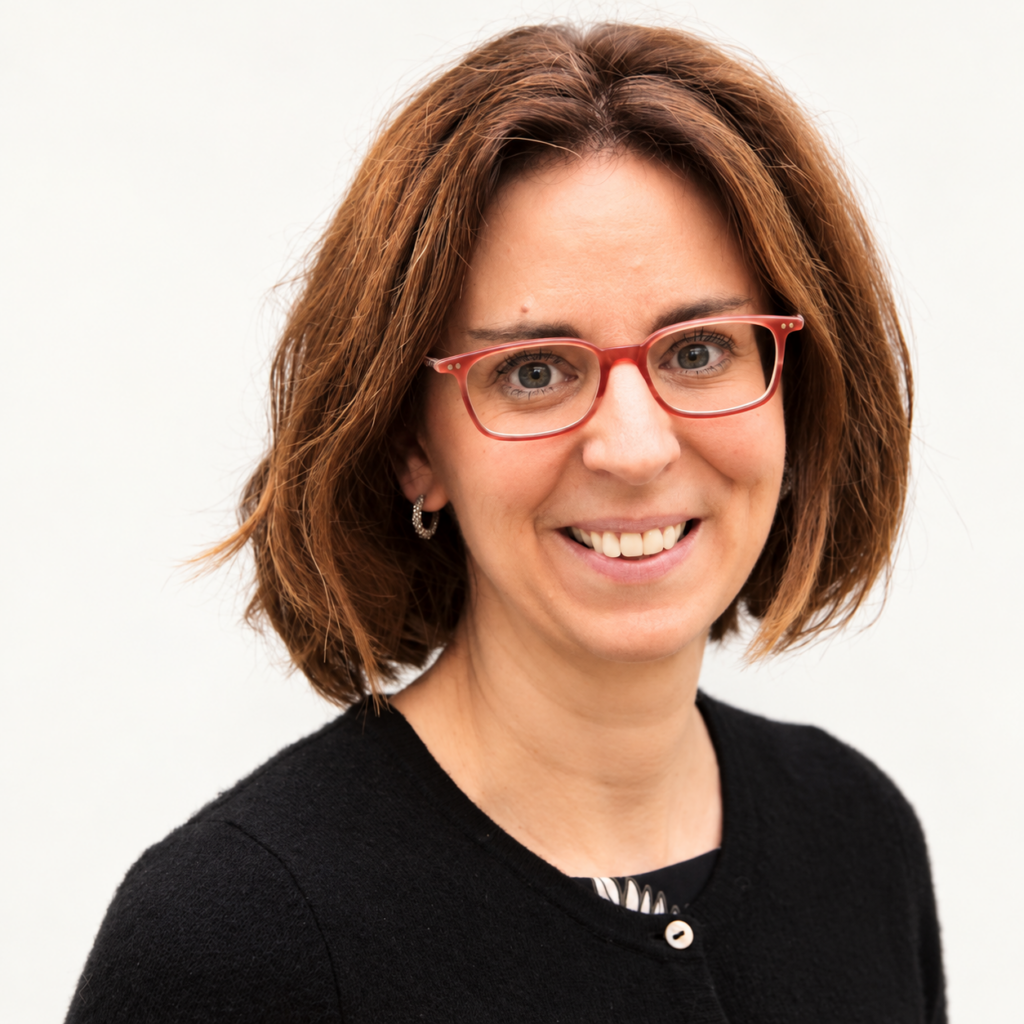 Businessporträt von freundlich lachender Frau mit roter Brille